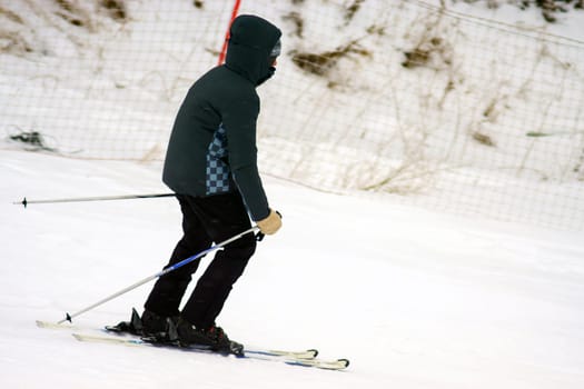 Person skiing down a slope, winter entertainment, winter time. Copy space