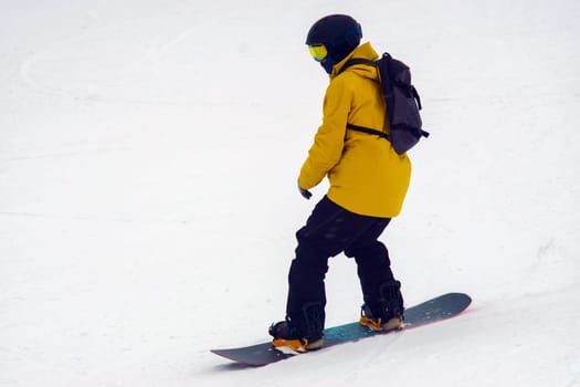 Man rides through the snow on a snowboard. Winter time, winter entertainment