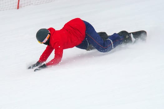 Man rides through the snow on a snowboard. Winter time, winter entertainment