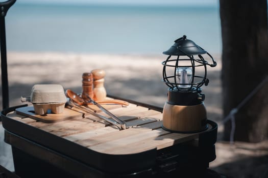 Camping essentials, a vintage kerosene lamp and a modern LED lantern on a wooden table. Enjoy nature, picnic, and a touch of nostalgia. A bright idea for your outdoor adventure.