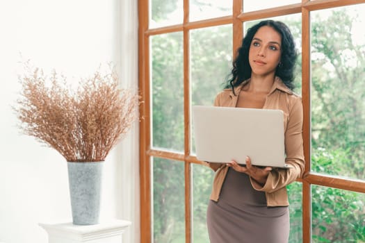 African-American woman using laptop computer for crucial work on internet. Secretary or online content writing working at home.