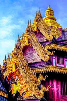 Traditional Thai Style Animal Gods Carved on Roof Decorations Against a Blue Sky