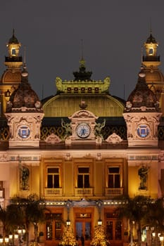 Monaco, Monte-Carlo, 12 November 2022: The famous square of Casino Monte-Carlo is at dusk, attraction night illumination, luxury cars, players, tourists, splashes of fountain. High quality photo