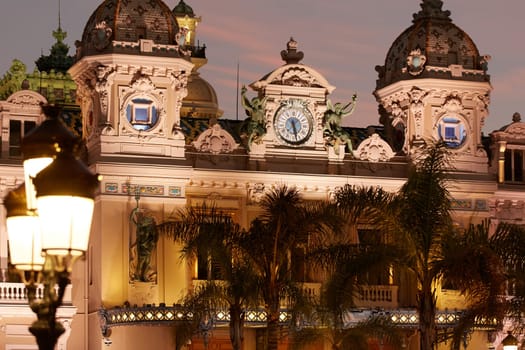 Monaco, Monte-Carlo, 12 November 2022: The famous square of Casino Monte-Carlo is at dusk, attraction night illumination, luxury cars, players, tourists, splashes of fountain. High quality photo