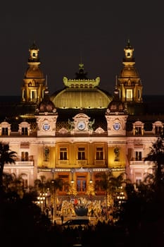 Monaco, Monte-Carlo, 12 November 2022: The famous Casino Monte-Carlo is at night, attraction night illumination, luxury cars, players, tourists, splashes of fountain. High quality photo