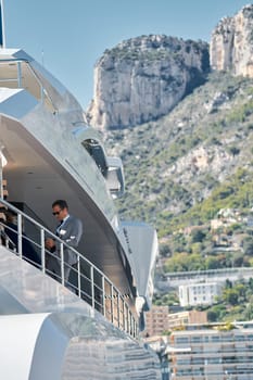 Monaco, Monte Carlo, 27 September 2022 - handsome man with smartphone on deck of mega yacht, Invited wealthy clients inspect megayachts at the largest fair exhibition in the world yacht show. High quality photo