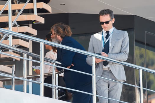 Monaco, Monte Carlo, 27 September 2022 - handsome man with smartphone on deck of mega yacht, Invited wealthy clients inspect megayachts at the largest fair exhibition in the world yacht show. High quality photo