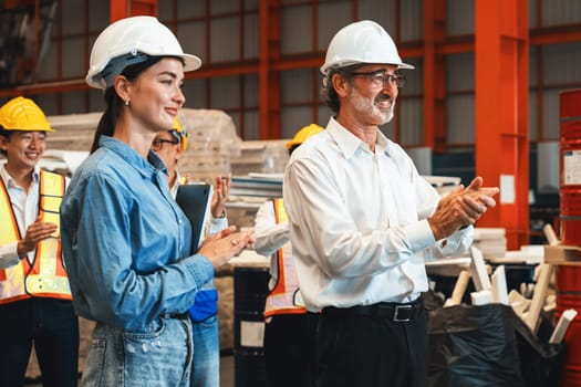 Happiness and joyful atmosphere, smiling factory worker and engineer celebrate with factory executive or manager after achieve factory output and surpassing the maximum quota. Exemplifying