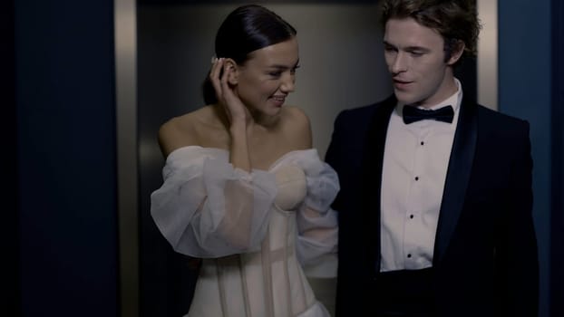 The bride and groom are walking hand in hand. Action. Models in wedding suits smile and walk around the room together posing for a photographer