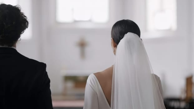 A beautiful couple walking through the church. Action.A view of the people from behind who decided to get married in a church. High quality 4k footage
