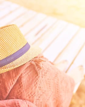 Straw hat on a hot day off on womans leg with plaid