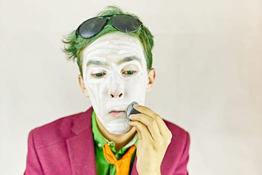 Man apply makeup. Mime uses a sponge to apply makeup.