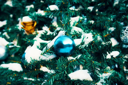 Decorated Christmas tree. Close-up of blue and gold balls hanging from a decorated Christmas tree.