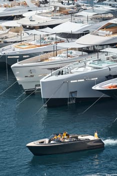 Monaco, Monte Carlo, 27 September 2022 - a boat with guests of yacht brokers departs from the shore in the largest fair exhibition in the world yacht show MYS, port Hercules, rich clients, sunny. High quality photo