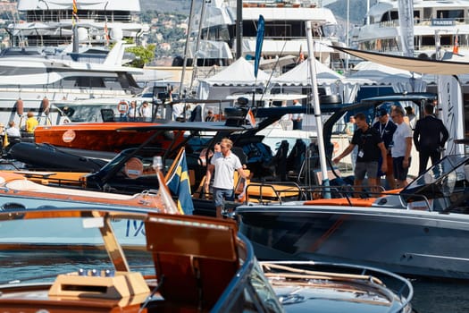 Monaco, Monte Carlo, 27 September 2022 - a boat with guests of yacht brokers departs from the shore in the largest fair exhibition in the world yacht show MYS, port Hercules, rich clients, sunny. High quality photo