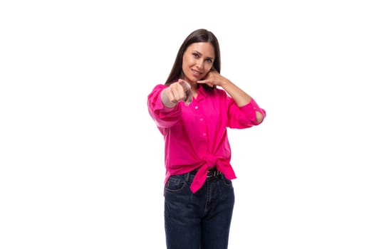 young cute caucasian brunette woman wears a pink shirt with tied ends at the waist.