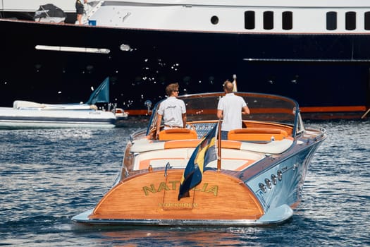 Monaco, Monte Carlo, 27 September 2022 - a boat with guests of yacht brokers departs from the shore in the largest fair exhibition in the world yacht show MYS, port Hercules, rich clients, sunny. High quality photo