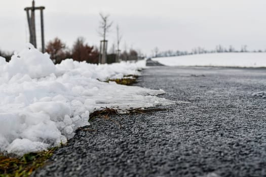 Road ploughed through by snow plough in winter. The concept of winter and winter road service.