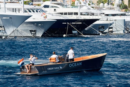 Monaco, Monte Carlo, 27 September 2022 - a boat with guests of yacht brokers departs from the shore in the largest fair exhibition in the world yacht show MYS, port Hercules, rich clients, sunny. High quality photo