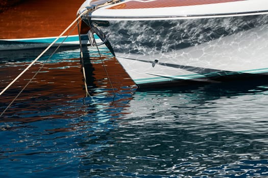 Sun glare on glossy board boats, azure water, tranquillity in port Hercules, bows of moored boats at sunny day, megayachts, Monaco, Monte-Carlo. High quality photo