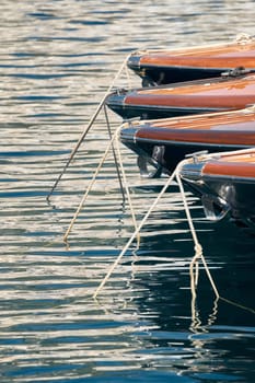 Sun glare on glossy board boats, azure water, tranquillity in port Hercules, bows of moored boats at sunny day, megayachts, Monaco, Monte-Carlo. High quality photo