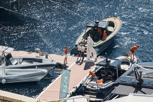 Monaco, Monte Carlo, 27 September 2022 - a boat with guests of yacht brokers departs from the shore in the largest fair exhibition in the world yacht show MYS, port Hercules, rich clients, sunny. High quality photo