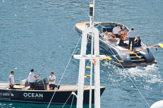 Monaco, Monte Carlo, 27 September 2022 - a boat with guests of yacht brokers departs from the shore in the largest fair exhibition in the world yacht show MYS, port Hercules, rich clients, sunny. High quality photo