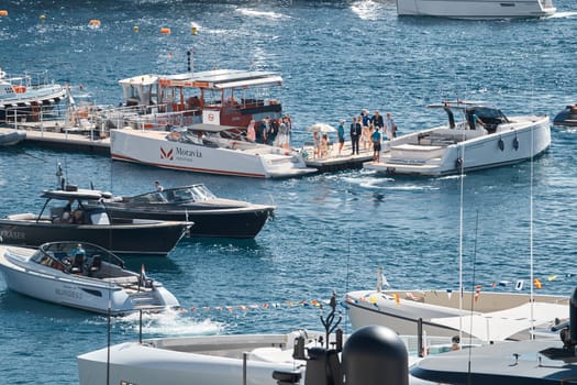 Monaco, Monte Carlo, 27 September 2022 - a boat with guests of yacht brokers departs from the shore in the largest fair exhibition in the world yacht show MYS, port Hercules, rich clients, sunny. High quality photo