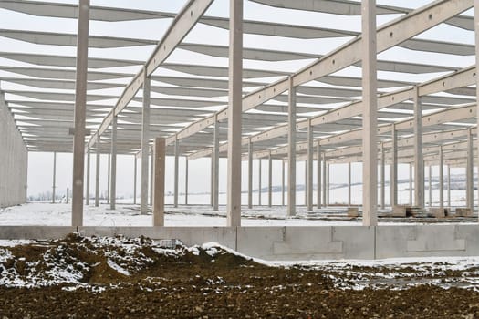 A dismantled factory hall in winter. Construction site during winter. The concept of the end of the building season and the completion of construction work before winter.