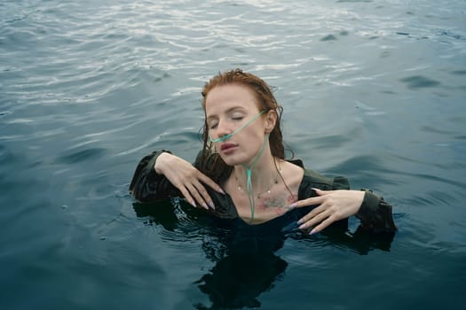 A girl with a breathing machine floats in the water. Girl swimming underwater in beautiful dress. High quality photo
