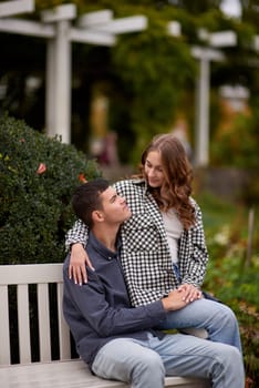 lovely young couple kissing outdoors in autumn. Loving couple walking in nature. Autumn mood. Happy man and woman hugging and kissing in autumn. Love. Fashionable couple outdoors. Fashion, people and lifestyle. Stylish couple in autumn outfit.