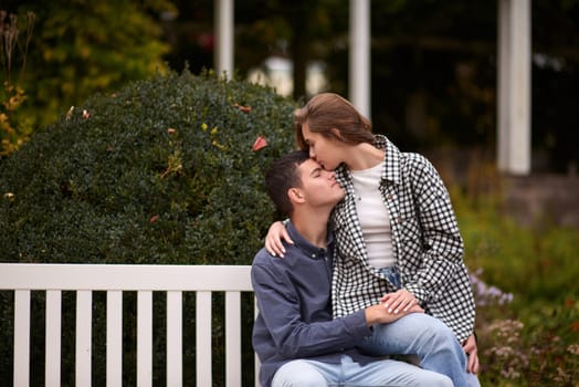 lovely young couple kissing outdoors in autumn. Loving couple walking in nature. Autumn mood. Happy man and woman hugging and kissing in autumn. Love. Fashionable couple outdoors. Fashion, people and lifestyle. Stylish couple in autumn outfit.