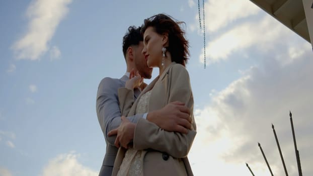 A gorgeous couple of young people. Action.A couple embracing on a city street, shot from different angles against the background of large towers and the sky. High quality 4k footage