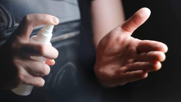 Men hands use hand sanitizer, spray pump to clean and get rid of epidemic viruses. Close up of applying spray disinfection alcohol product on hands against coronavirus bacteria.