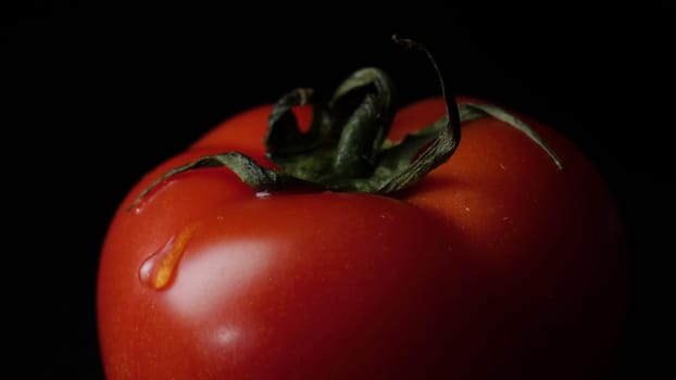 Drops of water dripping from above ripe tomatoes. Frame. Close up of a drop of water dripping from a tomato.