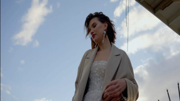 A couple embracing through the eyes of a photographer. Action.Newlyweds standing next to the bridge in nature with the wind blowing and gently hugging each other. High quality 4k footage