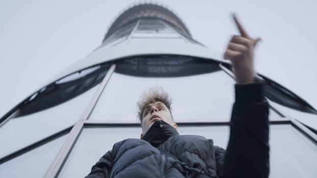 Bottom view of young man dancing with his hands. Action. Stylish young man in jacket dances in modern style. Modern hand dance in urban style.