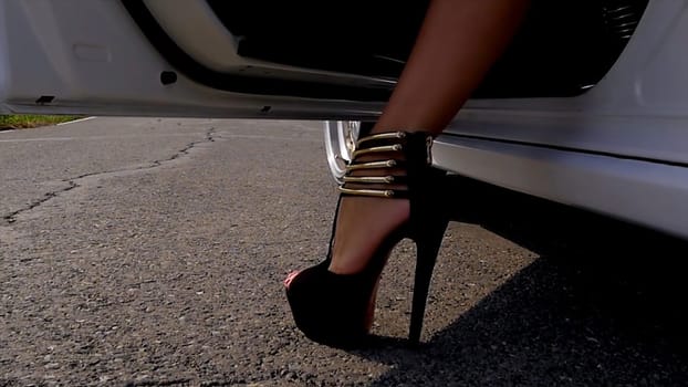 Young lady get out of the car. Woman getting out the car. Close up on the car door and the girl leg. Woman leg wearing black boots with high heel of driver in car with open door. Young lady get out of the car HD