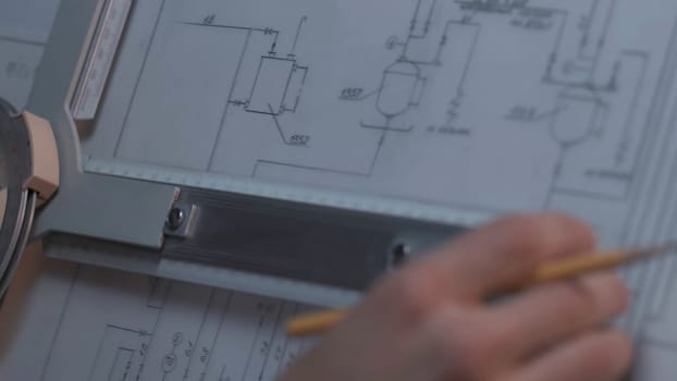 Close up of Architect hand sketching a construction project at work place. repair, building and home concept - close up of male hands making changes to blueprint