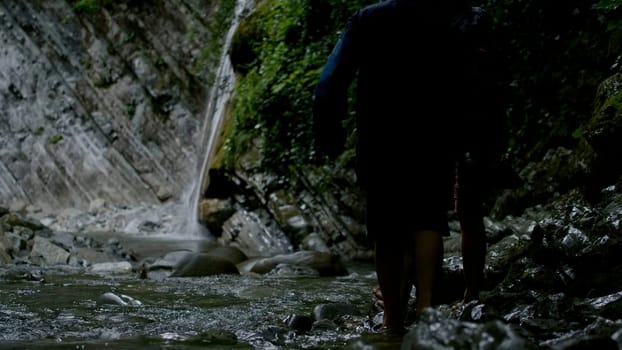 A walk on the rocks with a gushing stream. Creative.Small waterfalls with cold water where tourists swim and walk. High quality 4k footage