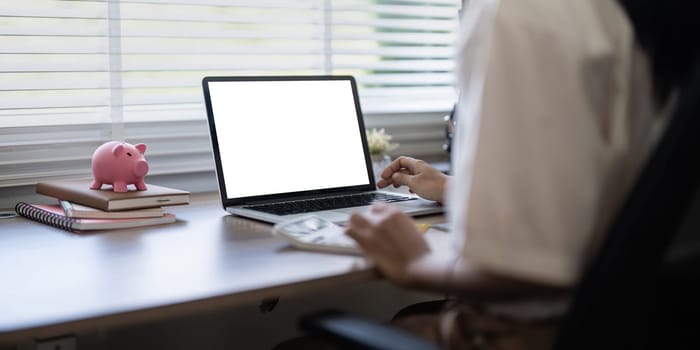 Laptop screen mock up, laptop in blank empty screen on the desk in home while woman working on financial calculating.