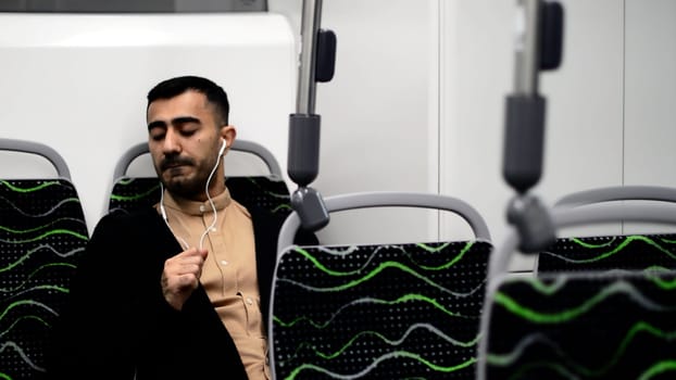 A handsome man dancing in transport. Motion.A stylish businessman who goes to work in an empty bus listening to music with headphones. High quality FullHD footage