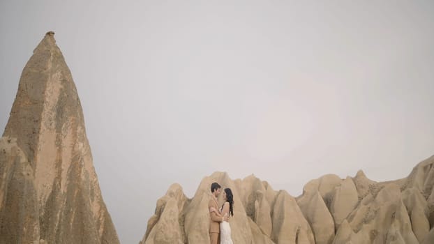 Beautiful photo shoot of the newlyweds in nature. Action. Nice views of the mountains and two loving people posing next to a pink car in nature in the summer