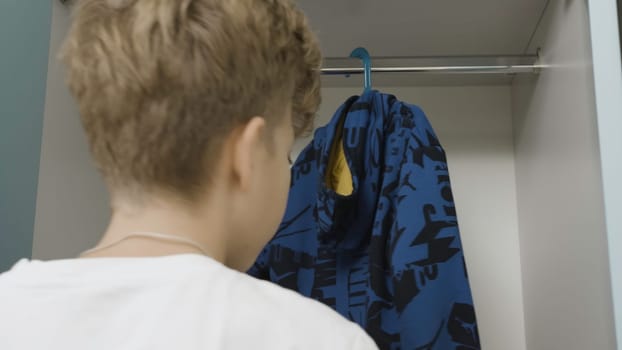 Beautiful white wardrobe. Creative . A room in which a boy hangs his clothes in a large white closet. High quality 4k footage