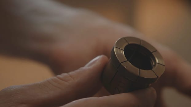 Production of rings. Jeweler working with wax model ring in his workshop. Craft jewelery making. Detail shot with low depth of field. Jeweler making handmade jewelry on vintage workbench. Craft of jewelery making. Repairing ring by inlaid tight gem.