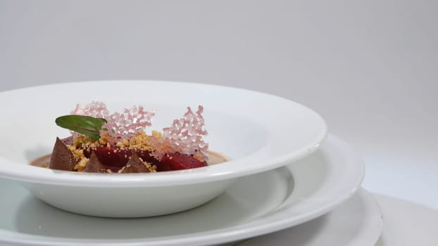 Salad of baked beets, arugula, cheese and nuts. Fresh salad with beets and oranges, food. Vegetarian lean lettuce from beet, onion, walnuts, serving on a white plate
