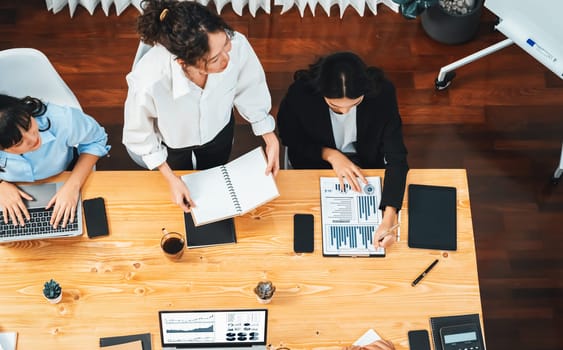 Panorama top view diverse group of business analyst team analyzing financial data report paper on meeting table. Chart and graph dashboard by business intelligence analysis. Meticulous