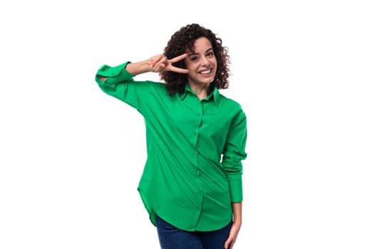 smiling office brunette woman with curly hair dressed in a green shirt on a white background.