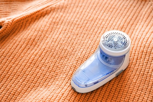 Color of the year 2024: Peach Fuzz. Device for shaving pellets clothes. Anti-Plush fabric Shaver. Electric portable sweater pill defuzzer. Lint remover from acrylic or wool sweater