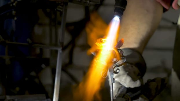 Blacksmith makes an iron rose. Man makes a rose out of iron.